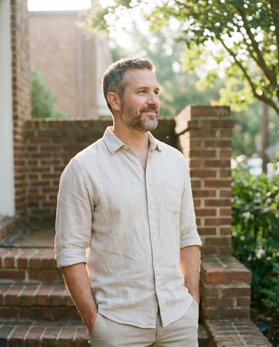 Confident man in his mid-40s standing outdoors in warm morning light